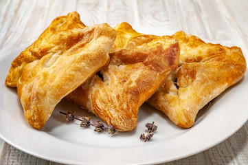 Fresh buns with vegetable filling and dried spice on a white plate.