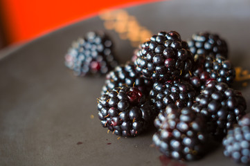 large juicy blackberry berries on a ceramic plate