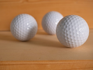 Golf ball on the wood floor.