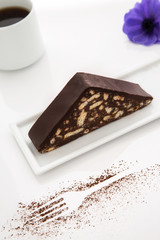 Cake slice, white porcelain coffee cup, white background, purple flower, cacao, fork shaped, white table top, close up, macro shot
