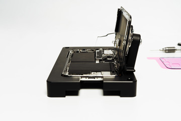Open Smart Phone Battery Change Repair Technology. Fix Smartphone Back Part Disassemble in Holder on White Background. Mobile Cellphone Assembly. Glass Screen Diagnosis Professional Service