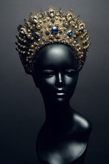 Head of mannequin in decorated bronze kokoshnick, dark studio background