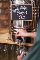 Man Filling Container With Cider Vinegar In Sustainable Plastic Free Grocery Store