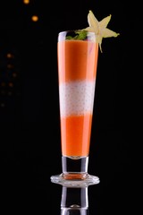 glass of fresh juice and carrots on white background
