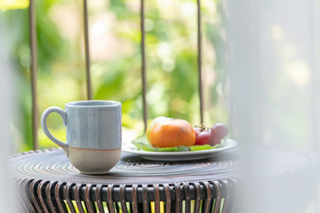 cup of coffee and fruits on wooden table