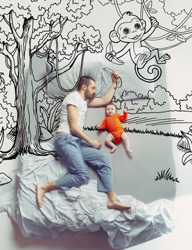Jungle and unity with nature. Top view photo of young man and his child sleeping in a big white bed. Dreams concept. Painted dream about travel, emotions, monkey, trees, grove and creepers.