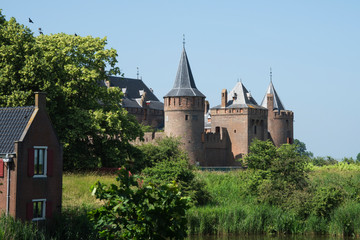 Fototapeta na wymiar Castle Muiderslot in Muiden, The Netherlands, against blue sky
