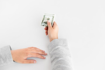 business, finance and corruption concept - close up of woman hand holding us dollar money on white background