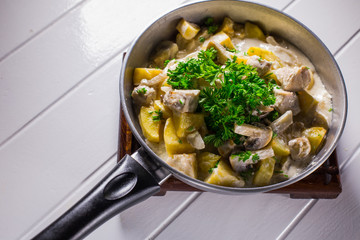 Fried potatoes with chicken, mushroom sauce and onion