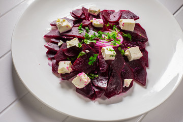 Vitamin salad with beets and Feta cheese in a white plate