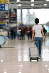traveler young woman walking with suitcase in an airport