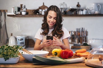 Beautiful young woman wearing apron cooking vegetables