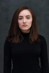 Portrait of a woman in a white dress with a long thick curly hair on gray background isolatad