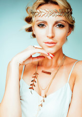 young blond woman dressed like ancient greek godess, gold jewelry and fashion makeup, people...