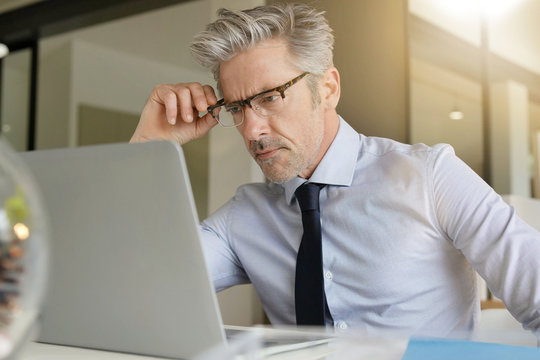 Businessman wearing glasses working in contemporary office