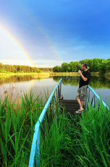 Relax. View of the forest lake after the rain. A man enjoys a beautiful view. 