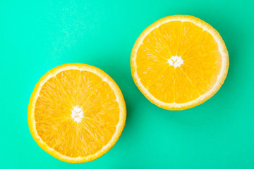 Fresh cut orange closeup on pastel green wall background. Bright image is suitable as a background, there is an empty space for text or logo. Top view