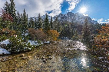 Obraz premium mountain lake in winter with calm open water and mountain wall behind