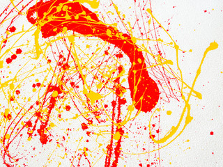 splashes of red and yellow paint on a white background