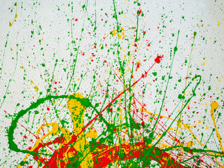 splashes of red and yellow green paint on a white background