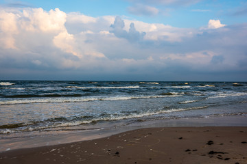 empty sea beach before storm with dramatic clouds and shadows from trees on the sand