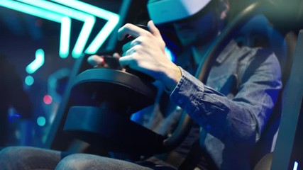 Young man in virtual reality headset playing videogame