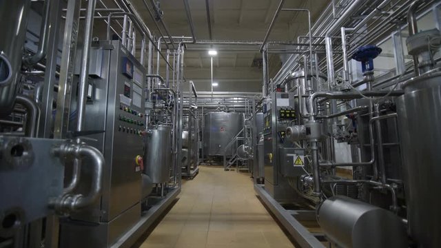 Pipeline at dairy factory. Huge cisterns for storing and fermenting milk. Equipment at dairy plant.