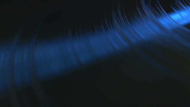 Close up footage of rotating professional vinyl record in soft blue light, view from above. More options in my portfolio