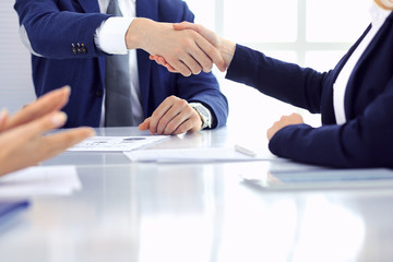 Group of business people or lawyers shaking hands finishing up a meeting , close-up. Success at negotiation and handshake concepts