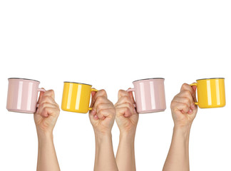 many raised hands up with ceramic cups on a white background