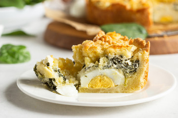 Tart or pie with spinach, ricotta and eggs.  Torta Pascualina, typical Italian Easter food. Light grey background. Copy space.