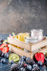 Summer fruits and berries smoothie drink. Vitamin diet snack beverage, with blueberries, strawberries, blackberries, kiwi. Dark blue concrete background copy space