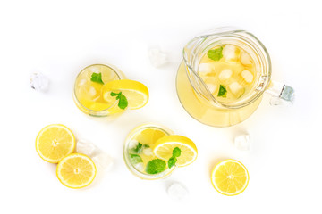 Homemade lemonade in glasses and a jar, with fresh lemons, mint, and ice cubes, shot from the top...