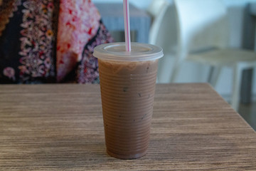 plastic glass of milk tea on wooden table