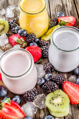 Summer fruits and berries smoothie drink. Vitamin diet snack beverage, with blueberries, strawberries, blackberries, kiwi. Dark blue concrete background copy space