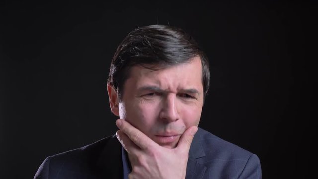 Cloesup shoot of adult attractive caucasian man having a sick throat while looking straight at camera with background isolated on black