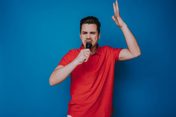 Low angle of Caucasian unhappy man talking into microphone in studio