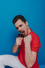 Half length of unshaven guy looking at camera with microphone in arm