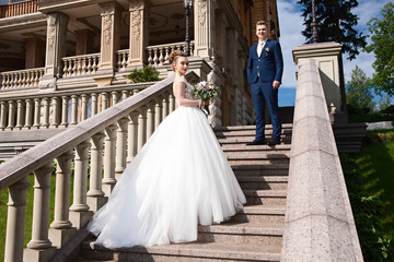Obraz premium Happy couple holding hands. Bride and groom holding hands and walking in the park. Selective focus
