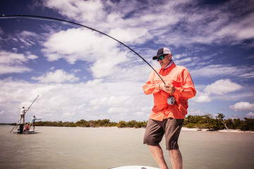 Fisherman salt water fishing with large fish on hook, caribbean
