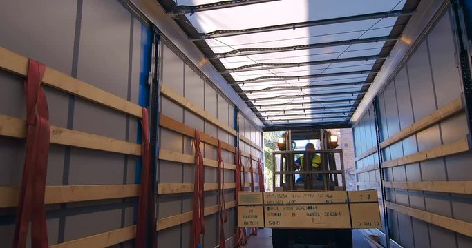 In the woodworking plant for the production of plywood and chipboard is loads by forklift wood products into the cargo truck 