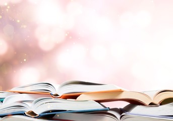 Books are opened and piled together on background
