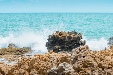 Beach rocks, sea water hitting the rocks on the bay. Pointed spongy rocks. Set of rocks near the sea at Praia de Coqueirinho beach, Brazilian northeast beach. Costa do Conde, Conde PB Brazil.
