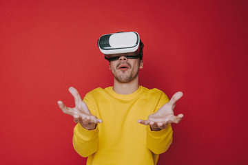 Low angle of surprised man touching something while situating in virtual reality