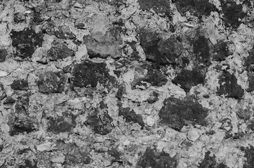 Old wall made of heavy rocks and concrete. Wall texture. Black and white.