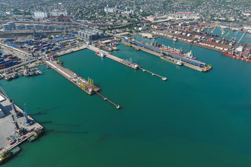 Obraz premium Industrial seaport, top view. Port cranes and cargo ships and ba
