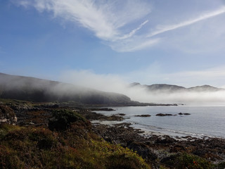 Fototapeta na wymiar Aufkommender Nebel am Tag mit Sonnenschein über der Bucht von Tarskavaig in Sleat auf der Isle auf Skye in Schottland
