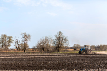 a tractor plows a field for sowing crops