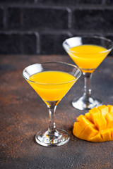 Tropical cocktail with mango on dark background