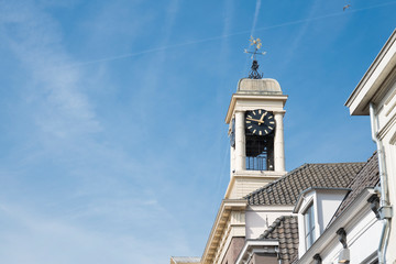 white tower of city hall with clock  in fortified city Harderwijk, Netherlands, against blue sky. Space for text